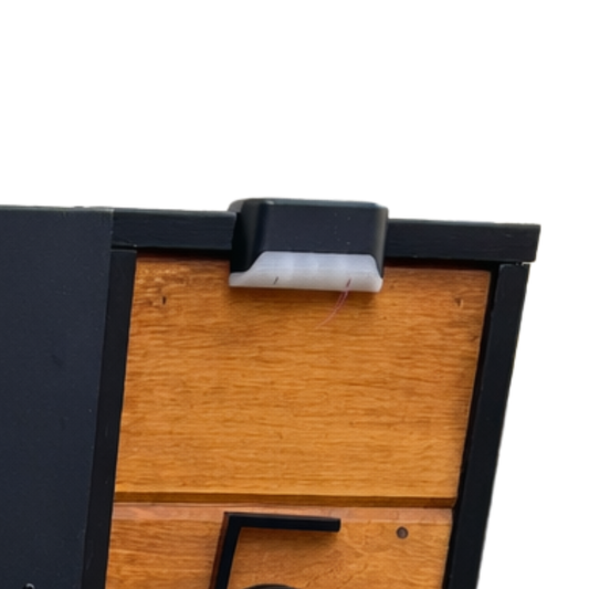 Wooden mailbox post with a black solar light mounted on a red wood plank