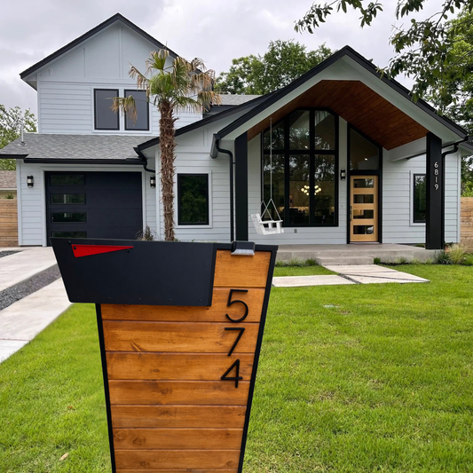 Modern house with a wooden mailbox post displaying the number 574.