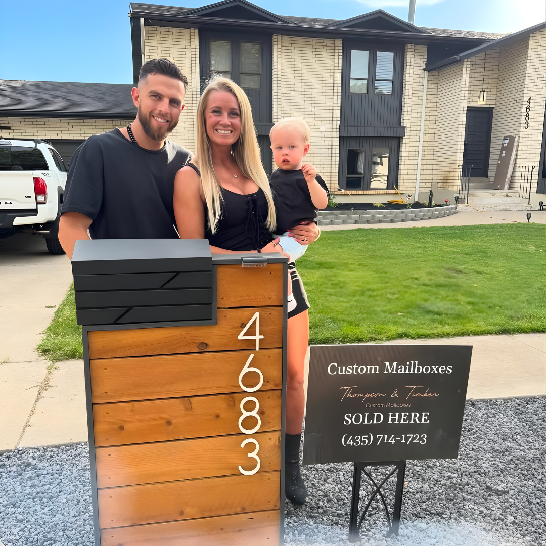 Owner's family in front of a house with a wooden mailbox post and sign.