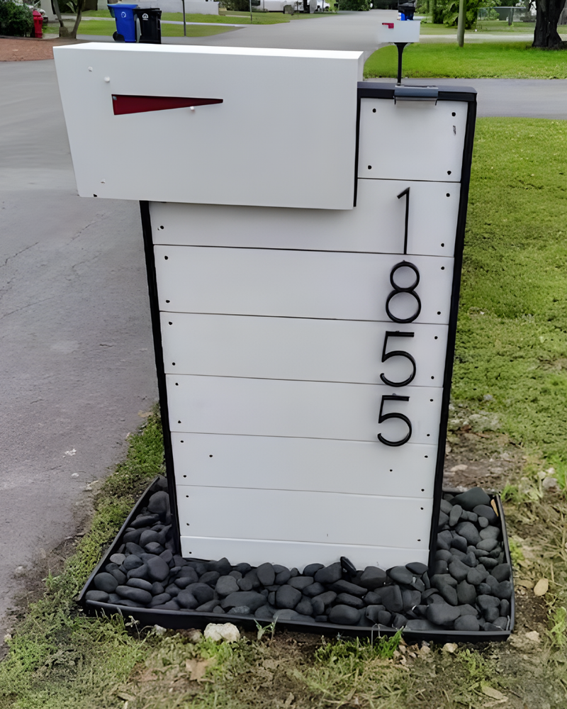 White mailbox with black address numbers on a grassy area