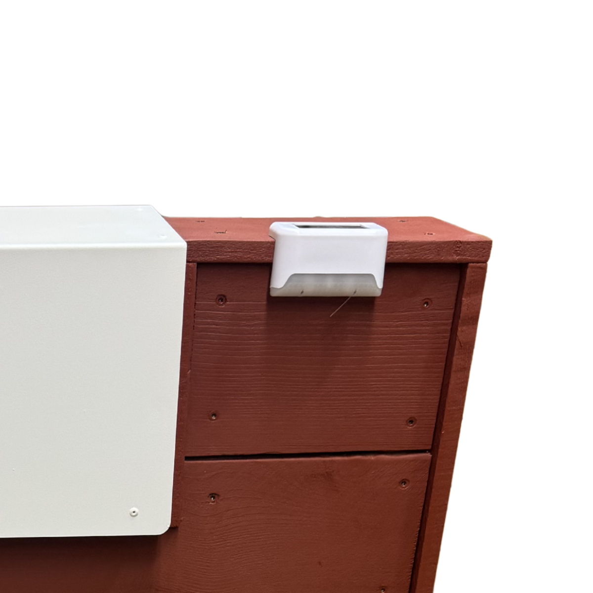 Wooden mailbox post with a white solar light mounted on a red wood plank