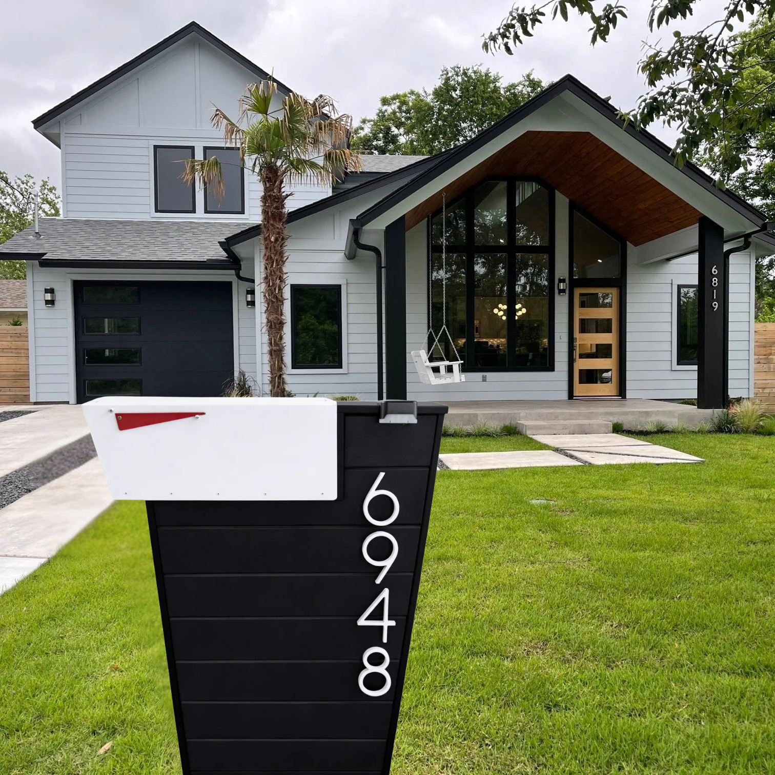 Modern house with a mailbox post displaying the number 6948 in front.