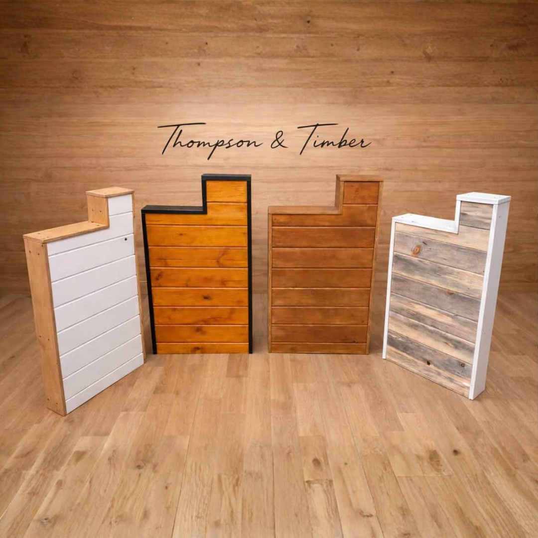 Wooden mailbox posts with 'Thompson & Timber' branding against a wooden wall.